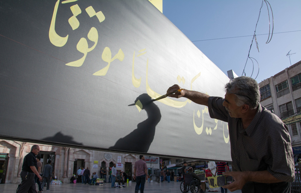 A calligrapher works on a banner in downtown Amman recently  (Photo by Amjad Ghsoun)